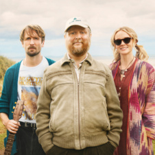 Two men and a woman looking at camera