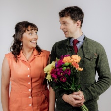 Man and Woman looking at each other. Man holding bunch of flowers